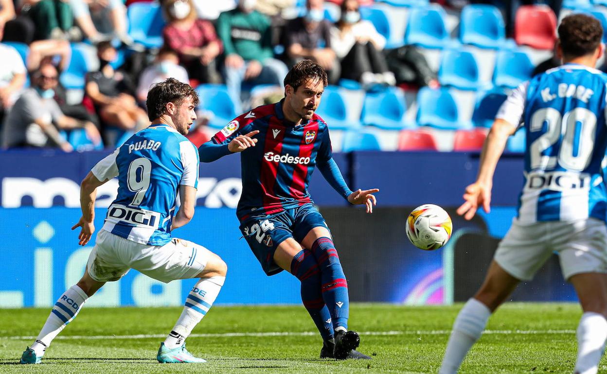 José Campaña golpea el balón ante la presión de Javi Puado.