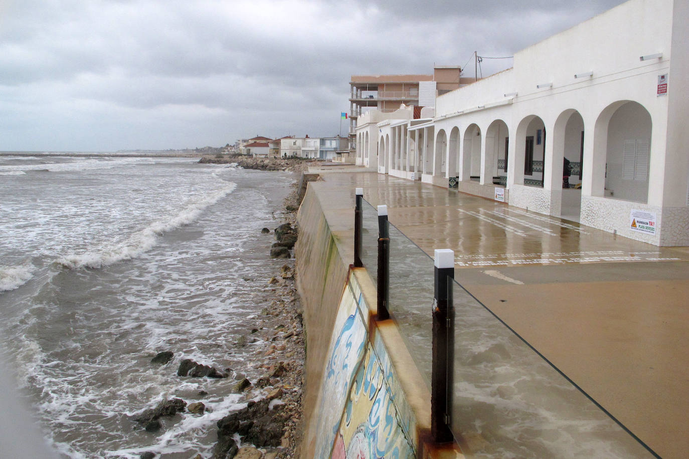 Playa de Les Deveses, con el mar llegando al muro de contención y casi sin tramo de arena por el oleaje y por elevarse el nivel del agua.