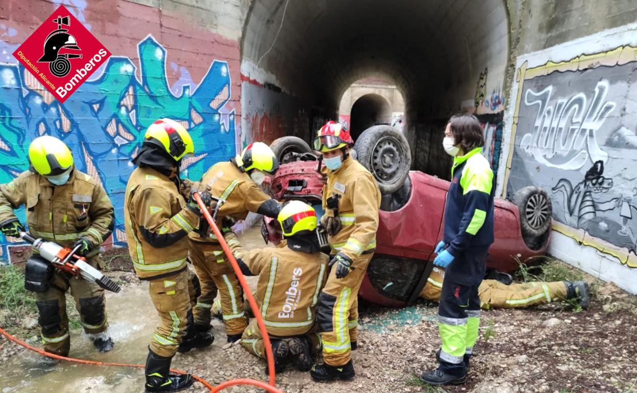 Los bomberos durante las labores de rescate de la conductora accidentada