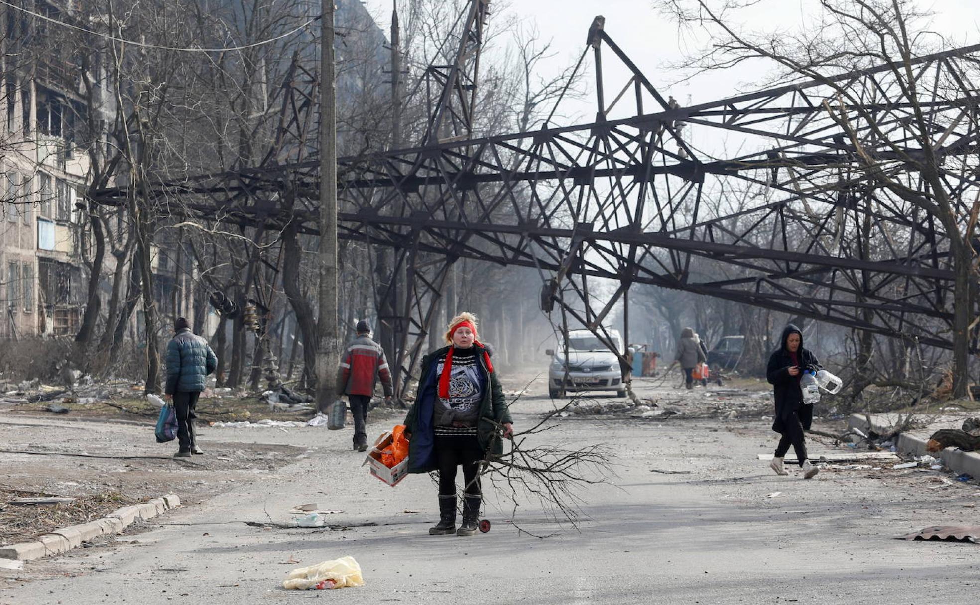 Una mujer ucraniana camina por una calle de la ciudad destrozada de Mariupol. 