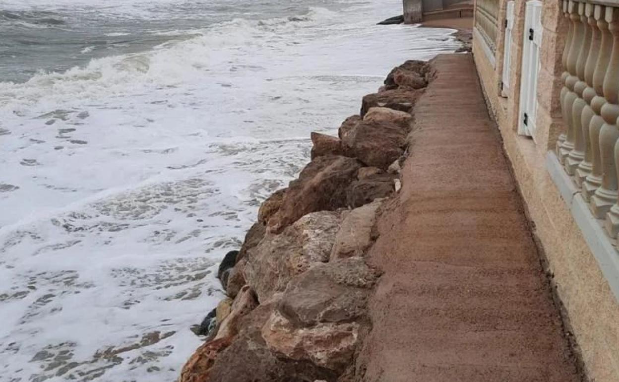 Estado de la playa de Tavernes, donde la falta de arena hace que las olas rompan en las viviendas y generen daños. 