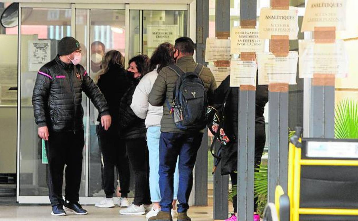 Usuarios haciendo cola para entrar en un centro de salud de Valencia. 