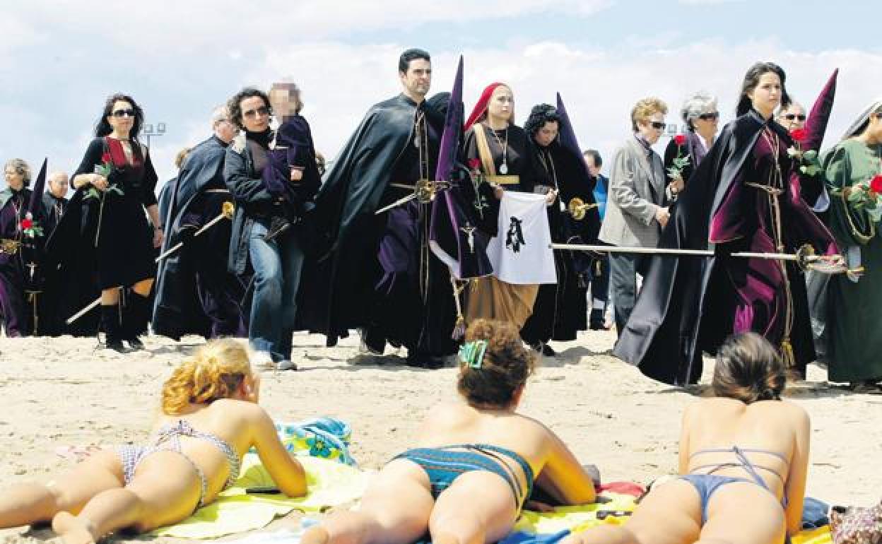 Unas bañistas observan una procesión en Valencia, en una imagen de archivo.