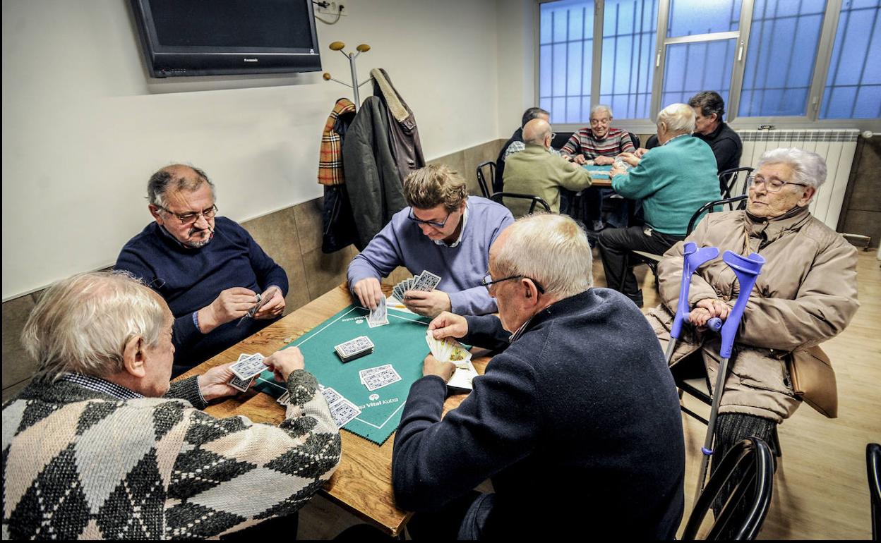 Jubilados jugando a las cartas en un centro de mayores.