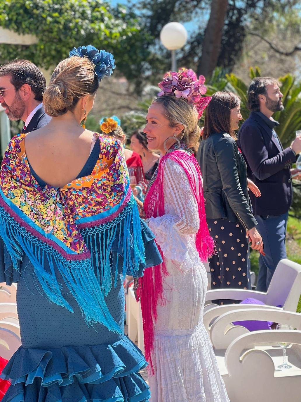 Flores en la cabeza, mantones de manila y trajes de sevillana para una fiesta benéfica.