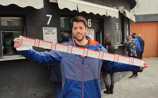 Un aficionado posa con sus entradas para la final