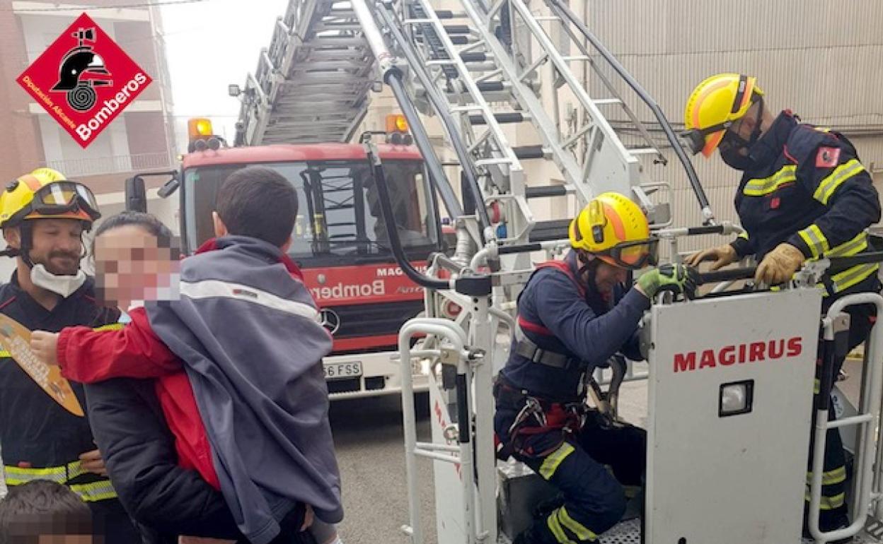 La madre abraza a su hijo después del rescate de los bomberos. 