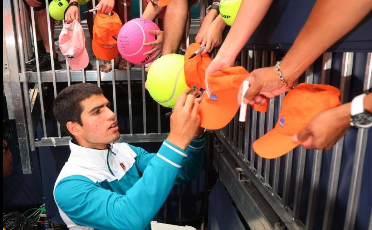 Carlos Alcaraz firmando autógrafos.