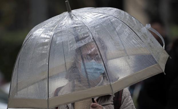 Una mujer se protege de la lluvia en Valencia. 