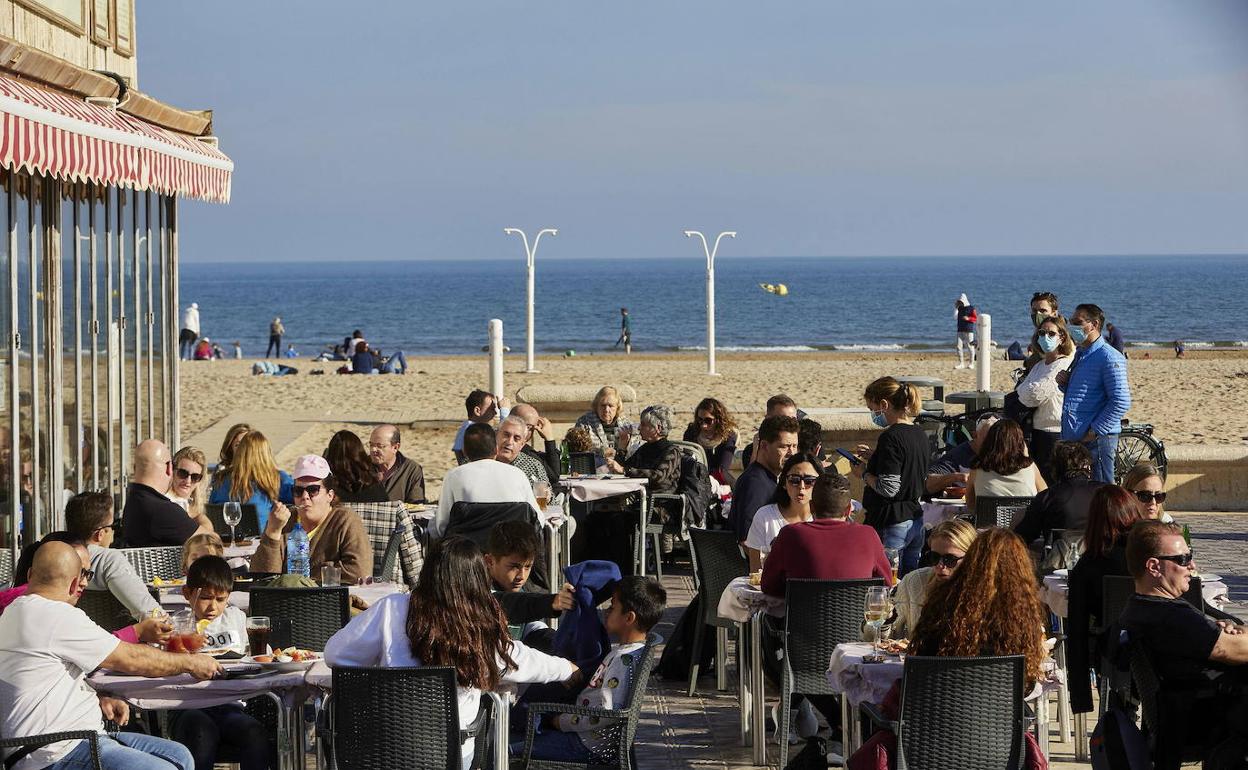 Turistas y valencianos, disfrutando de una terraza del paseo marítimo de Valencia. 