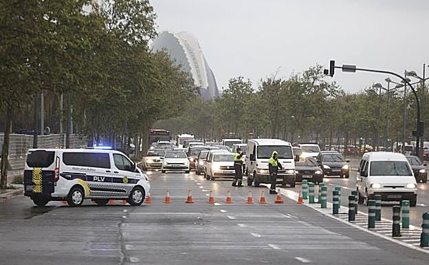 Imagen principal - Dispositivo policial y colas a la salida de Valencia, este miércoles.