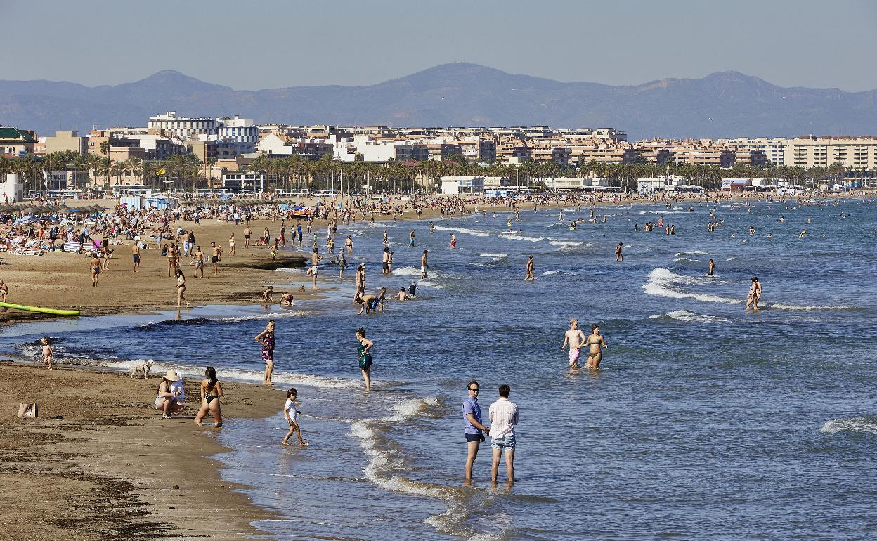 Turistas disfrutan de la playa en la costa valenciana. 