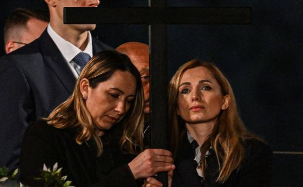 Irina y Albina portan la Cruz durante la XIII estación del Vía Crucis en el Coliseo de Roma.