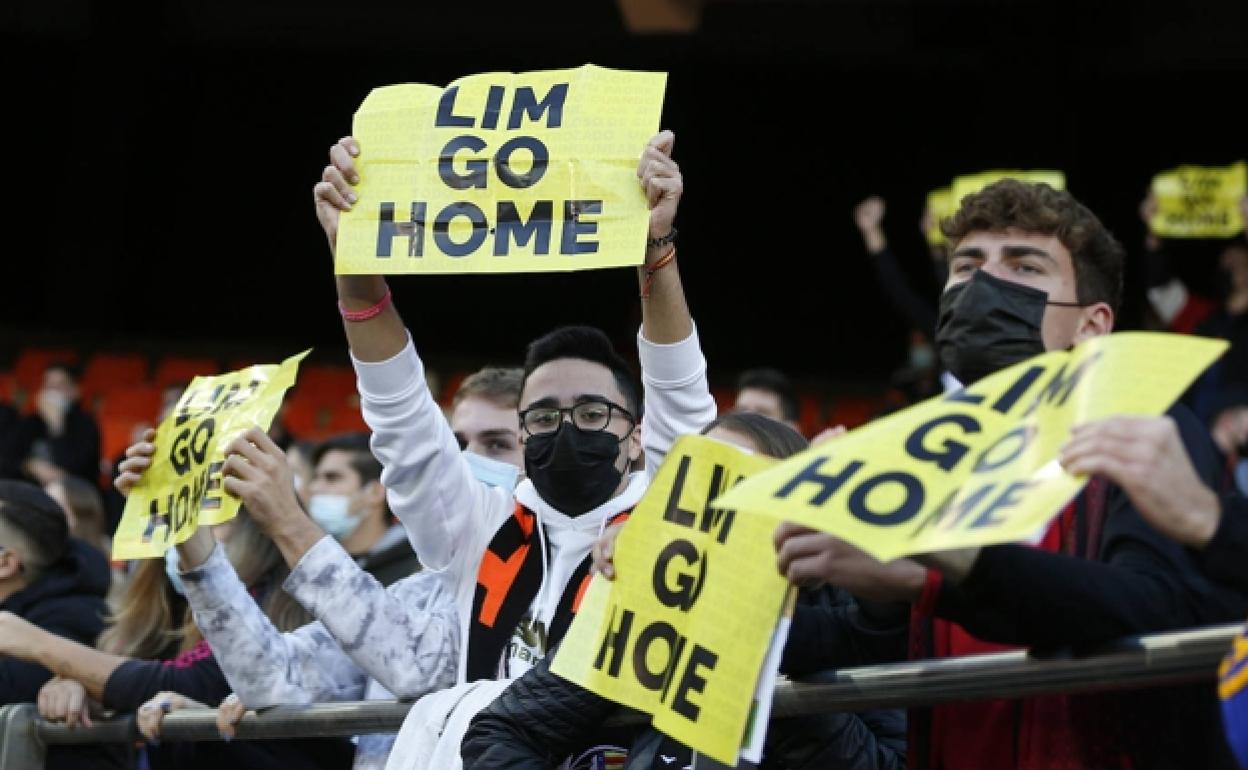 Aficionados del Valencia, mostrando los carteles en contra de Peter Lim