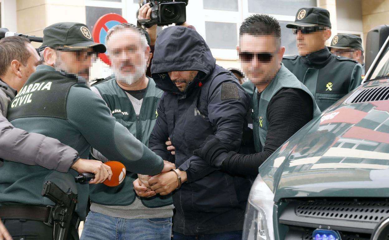 Varios guardias civiles trasladan al presunto asesino al juzgado de Alzira. 