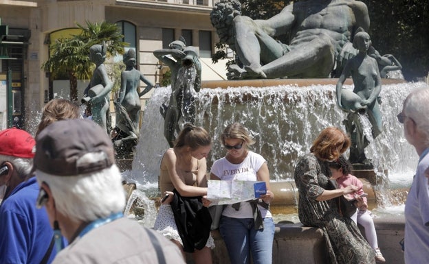 Turistas y visitantes, en la plaza de la Virgen, disfrutando del sol. 