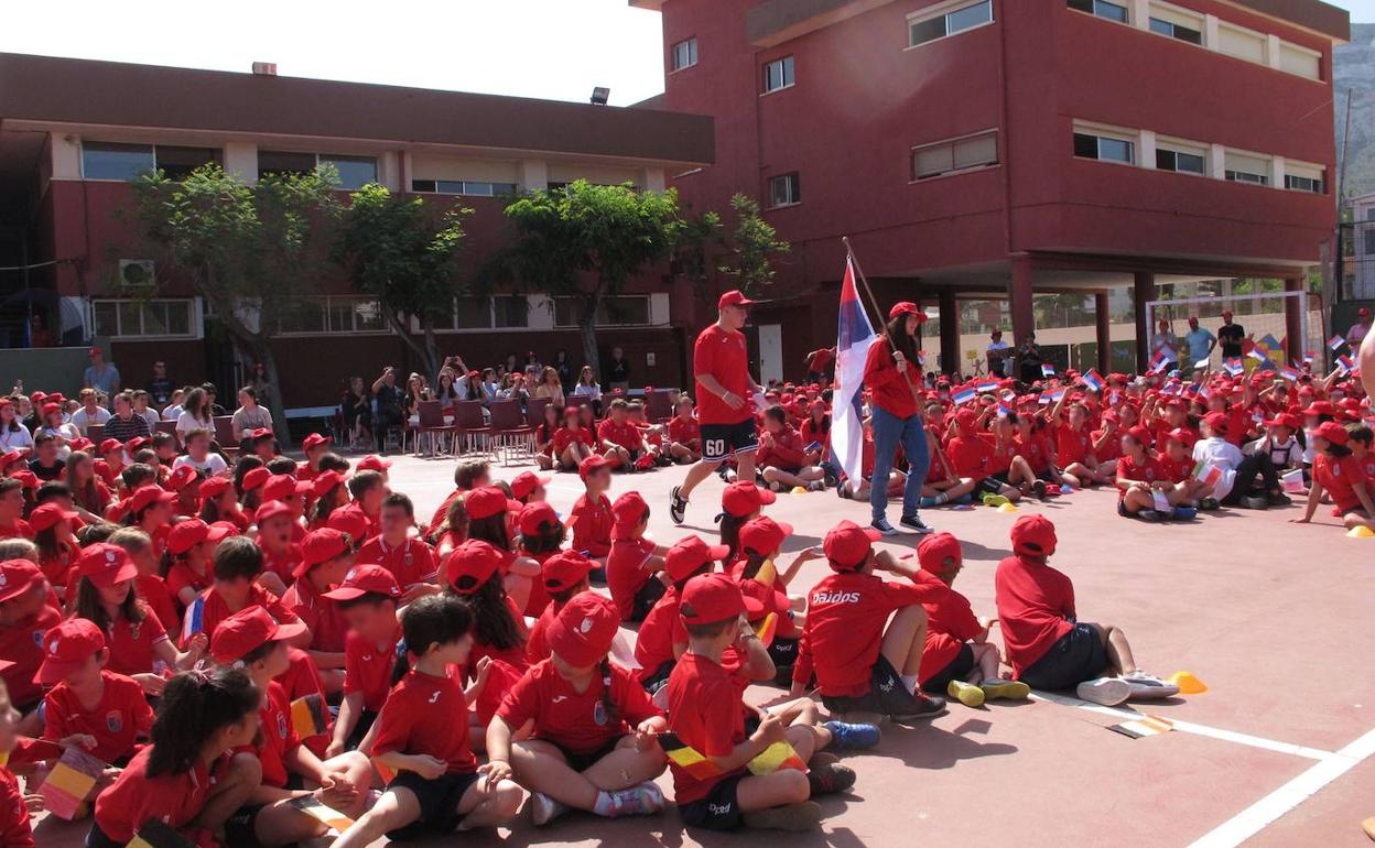 Los alumnos de Paidos atentos a la entrada de la bandera de Serbia. 