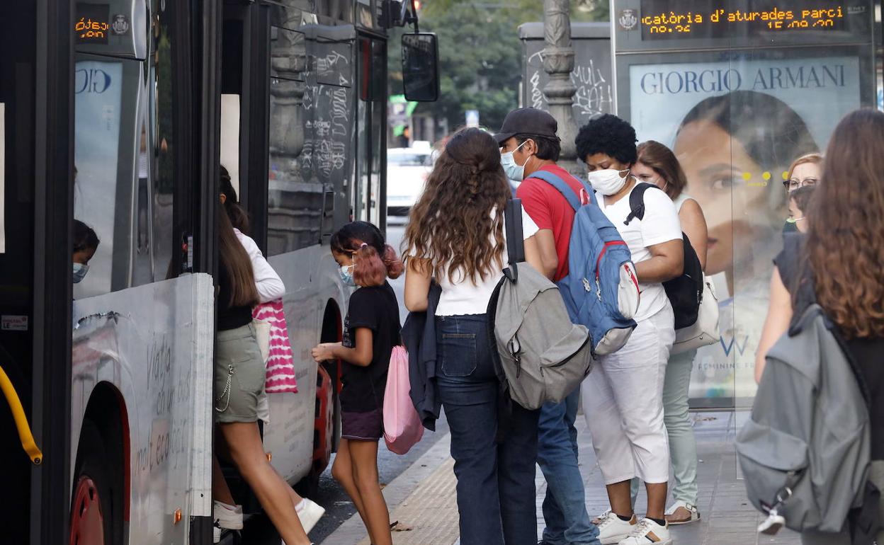 Usuarios de autobús de la EMT en una parada.