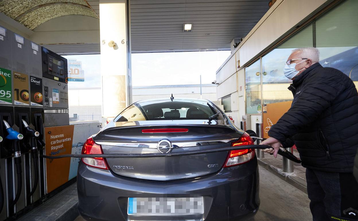 Un hombre reposta su coche en una gasolinera. 