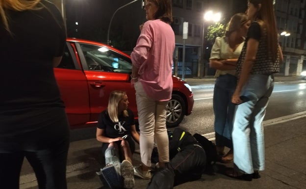 Una mujer tranquiliza al herido mientras esperan la llegada de la ambulancia. 