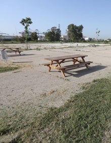 Imagen secundaria 2 - Maleza en el parque de Nazaret, un operario desbrozando la zona y mesa de picnic sin sombraje alguno. 