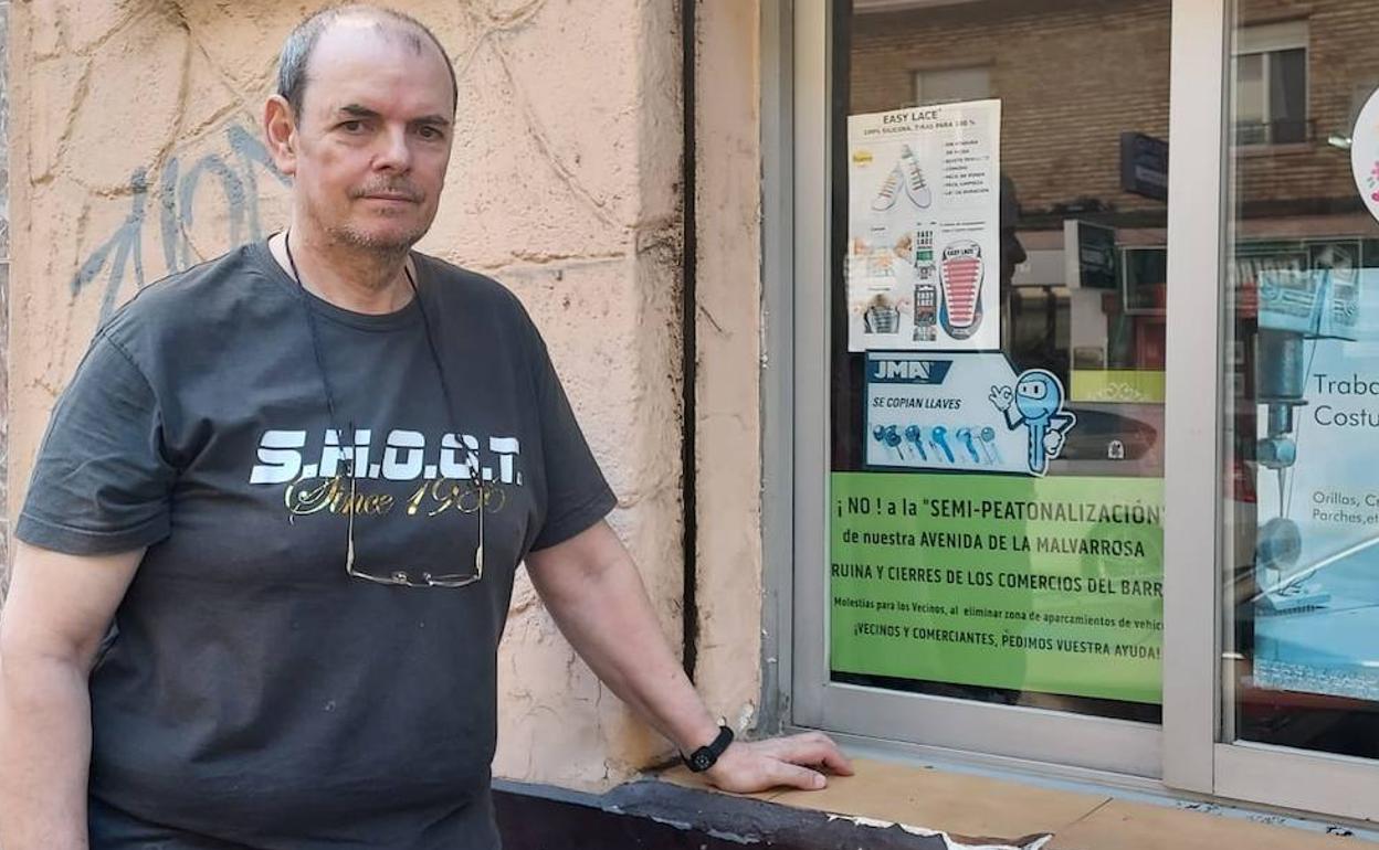 Rafa Prieto, uno de los comerciantes de la avenida Malvarrosa, junto al cartel en contra de la peatonalización. 