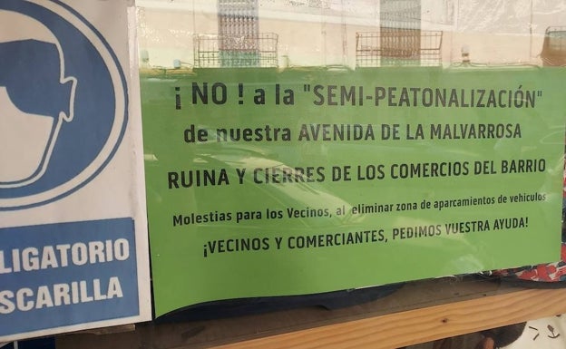 Otro local comercial, con el cartel de protesta en la Malvarrosa. 