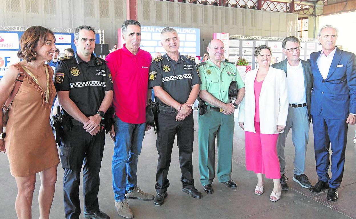 Dori Ruano y Miguel Indurain posan con agentes de seguridad, autoridades y organización antes de la presentación del evento.