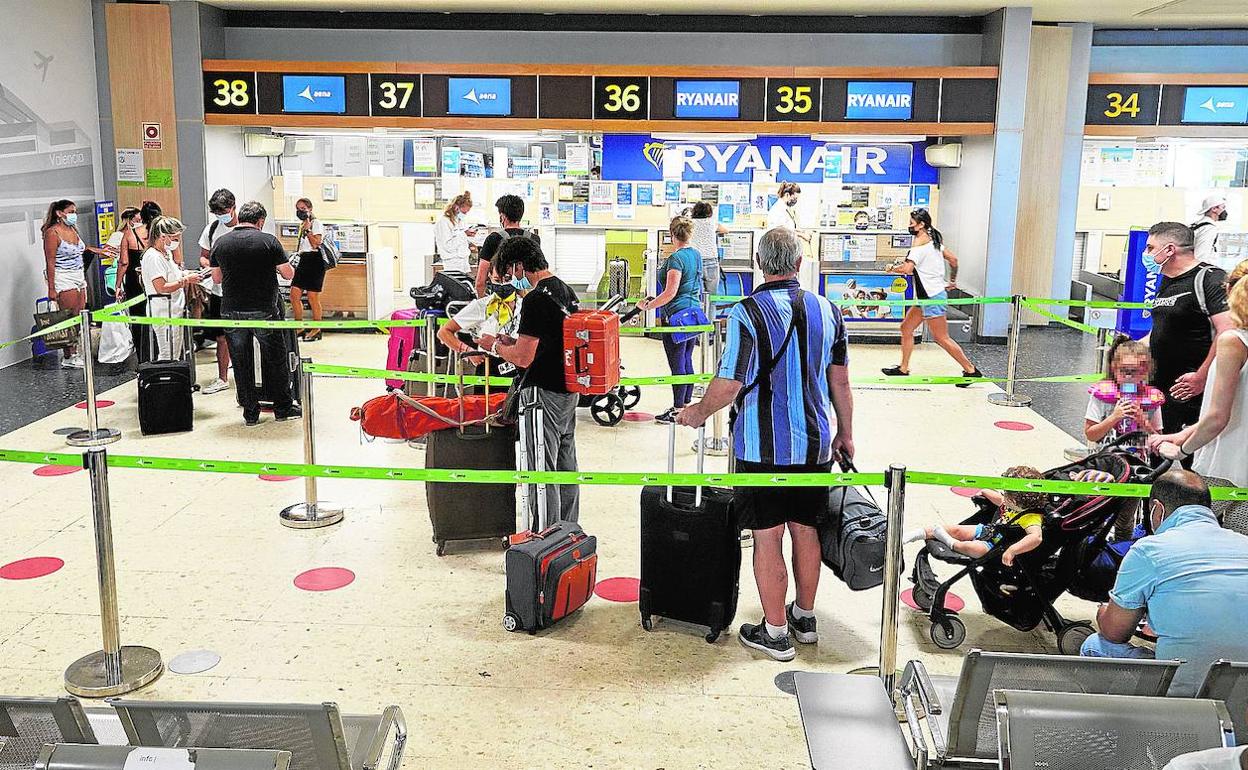 Unos pasajeros esperan para facturar su equipaje en el aeropuerto de Manises.