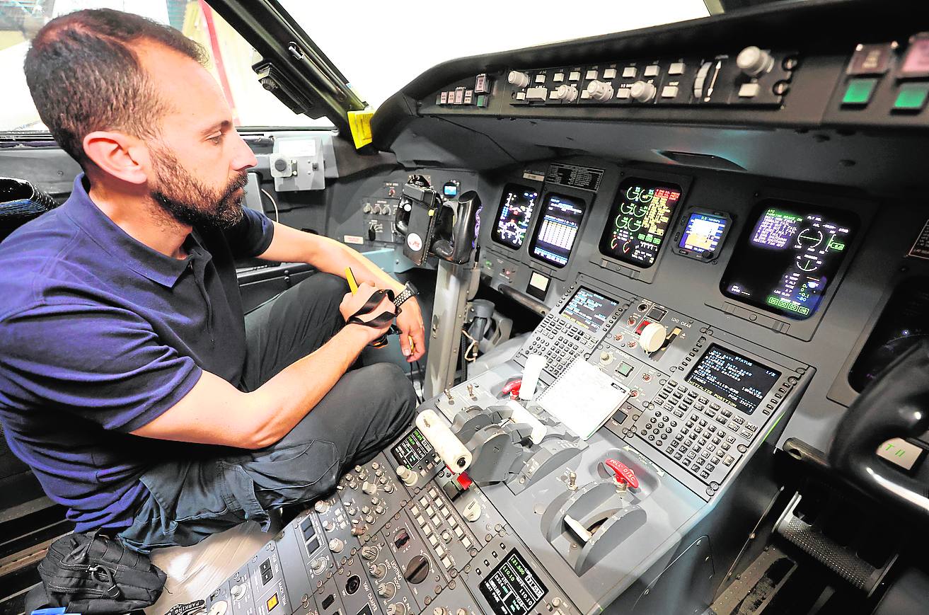 Electrónica. Un mecánico comprueba el correcto funcionamiento de los paneles de control de la cabina de los pilotos.