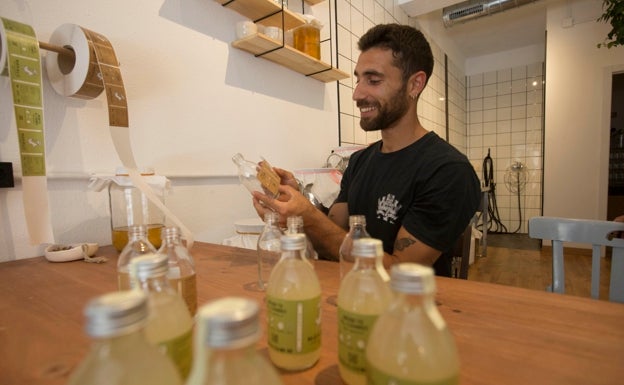 Álex Medina etiqueta las botellas de Makalú Kombucha en su tienda 