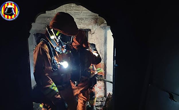 Bomberos extinguien el incendio de la vivienda.