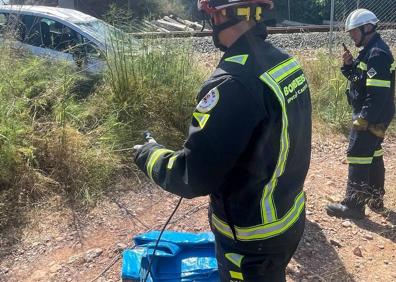 Imagen secundaria 1 - Efectivos de bomberos trabajando en la zona del accidente. 