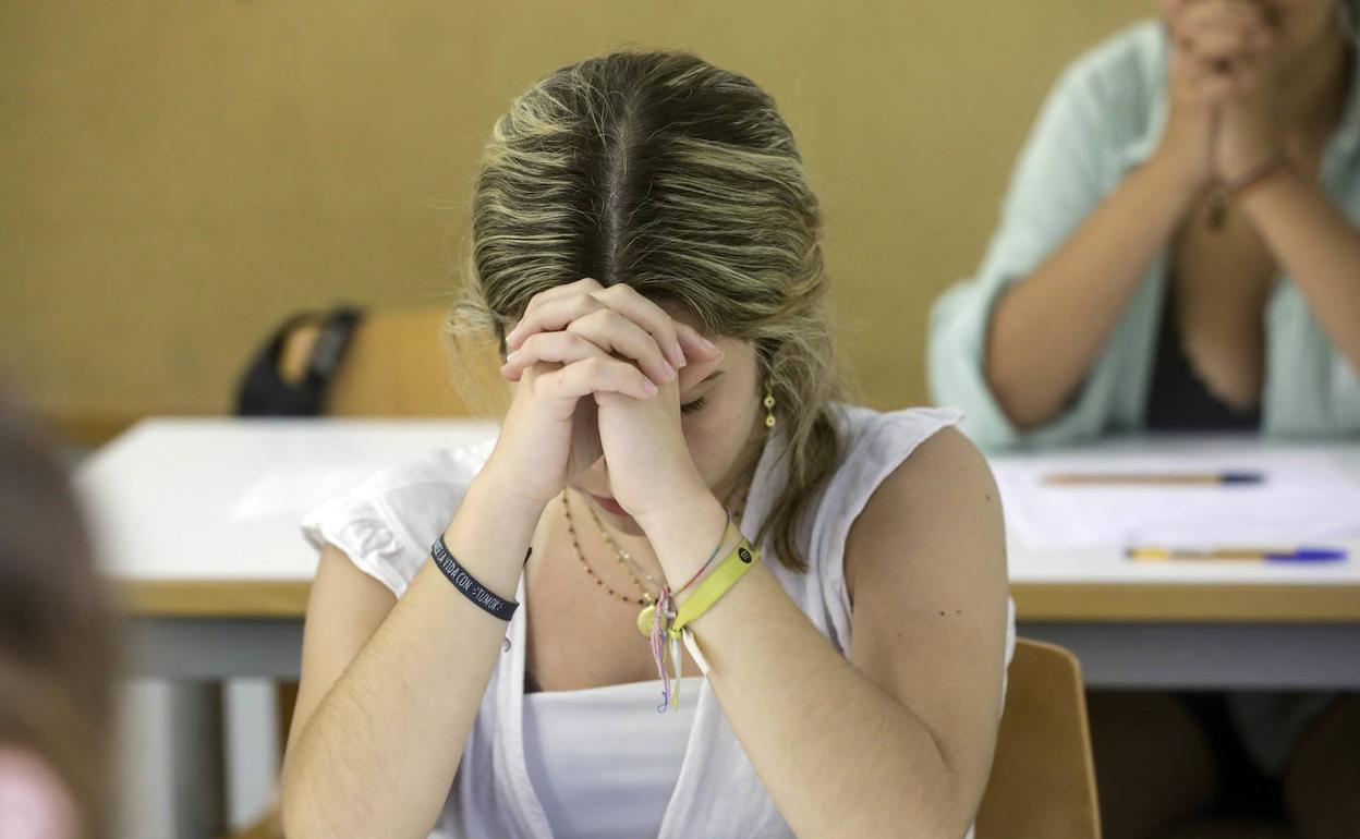 Una alumna revisa el examen de Historia de España tras ser repartido. 