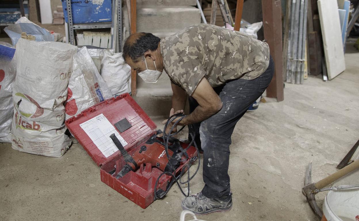 Un albañil trabajando en la reforma de un local. 