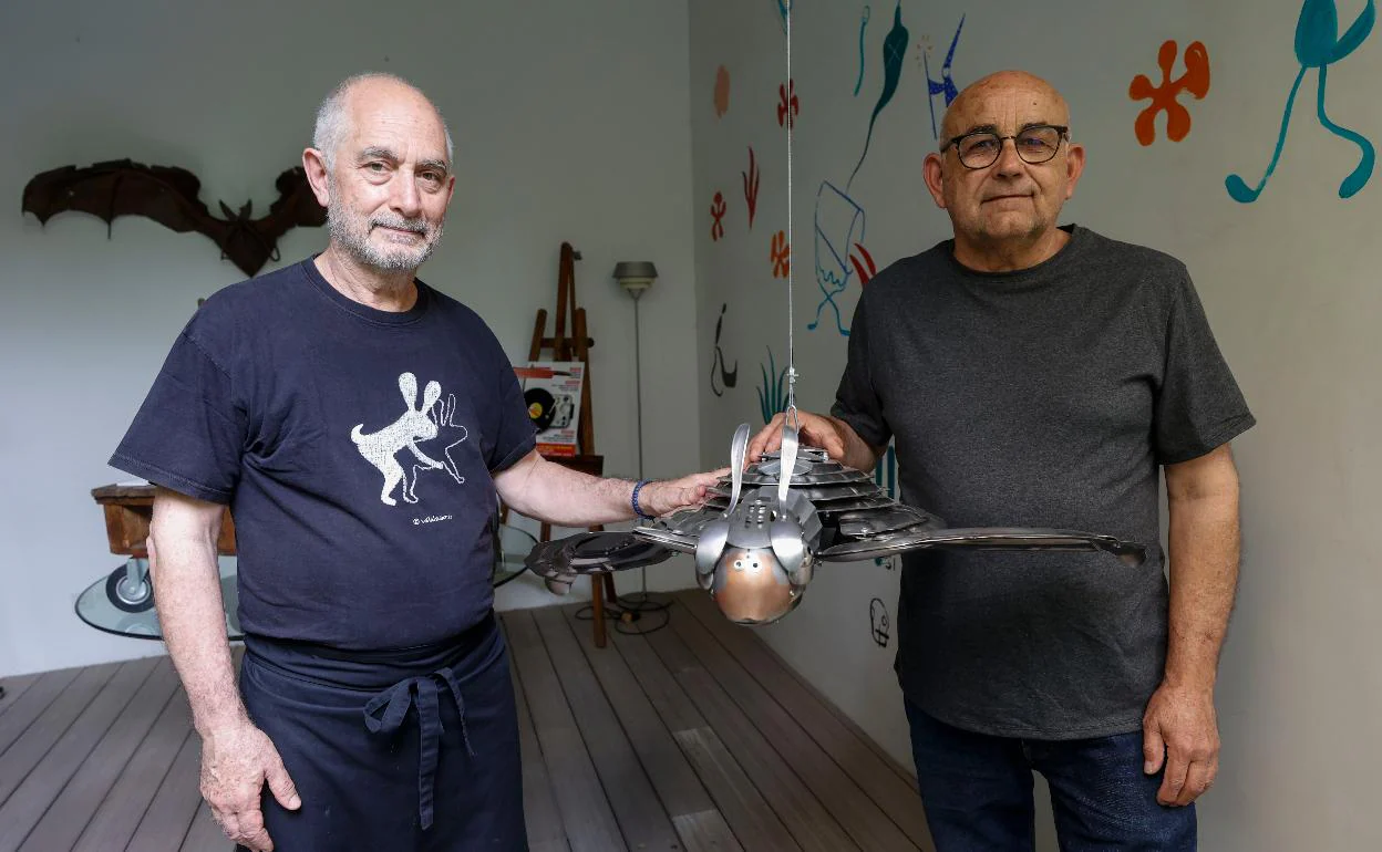 Joaquín Schmidt y Benja Carreres posan con una de las obras expuestas en el restaurante.