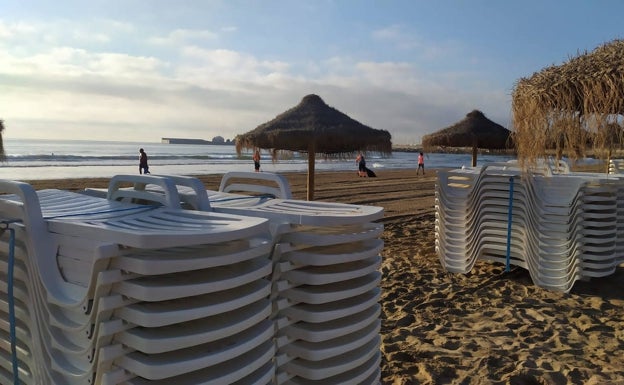 Procesio de montaje de sombrillas y hamacas en la playa del Cabanyal. 