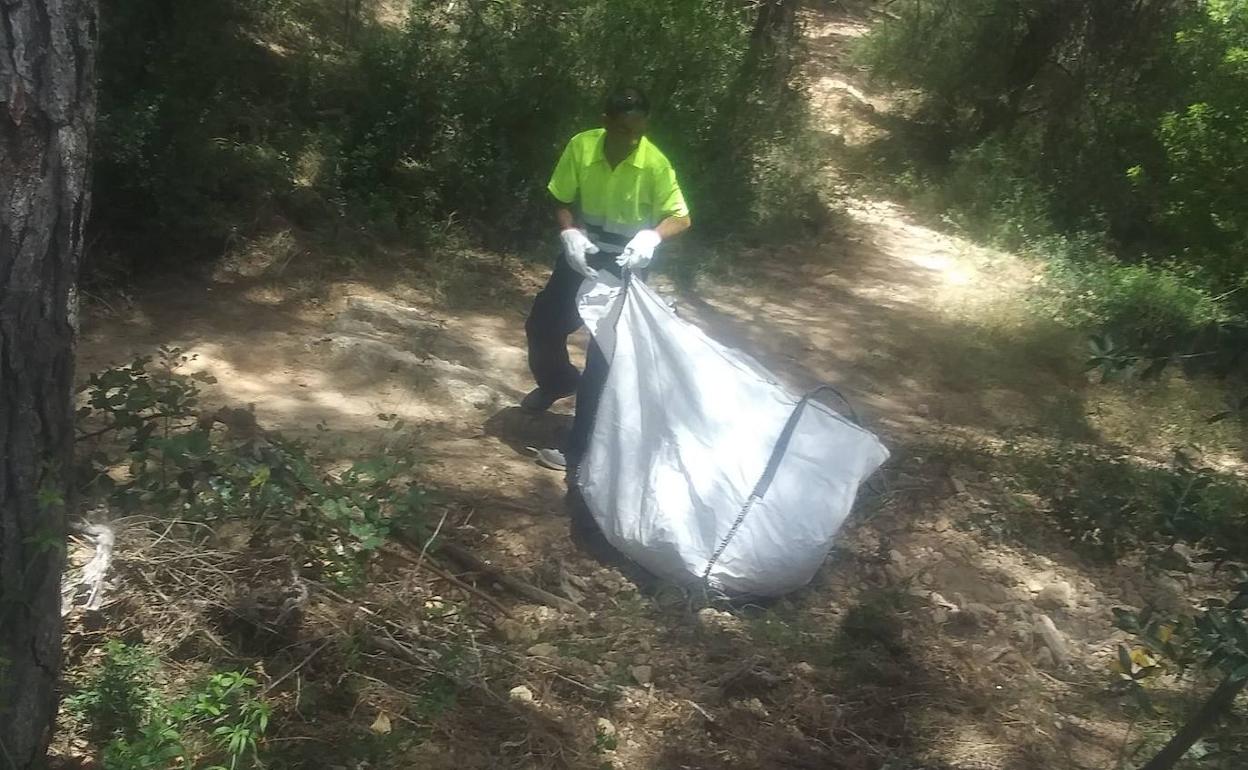 Un trabajador arrastra de una de las bolsas caragada con toallitas. 