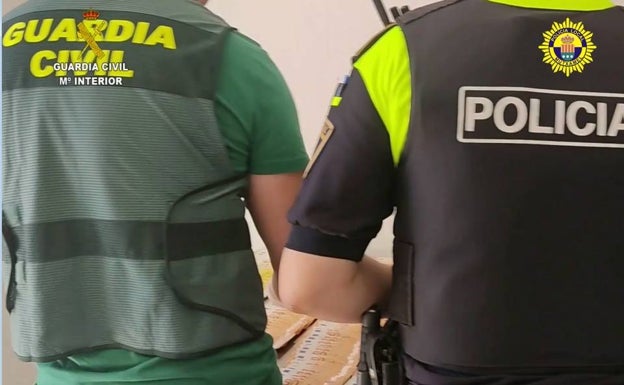 Los agentes cuentan los 30.000 euros que tenían los detenidos en el domicilio. 