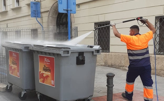 Un operario limpia los contenedores habilitados en hogueras. 