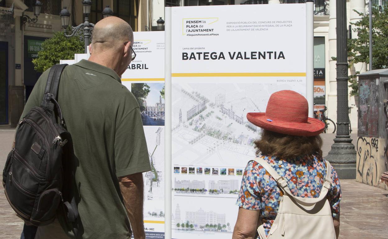 Dos personas observan uno de los paneles del concurso de la plaza del Ayuntamiento. 