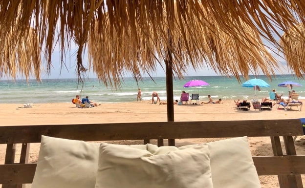 Imagen principal - Vistas de las instalaciones de Malibú, clientes degustando una comida y algunas de sus sombrillas, todo frente al mar. 