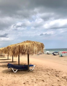 Imagen secundaria 2 - Vistas de las instalaciones de Malibú, clientes degustando una comida y algunas de sus sombrillas, todo frente al mar. 