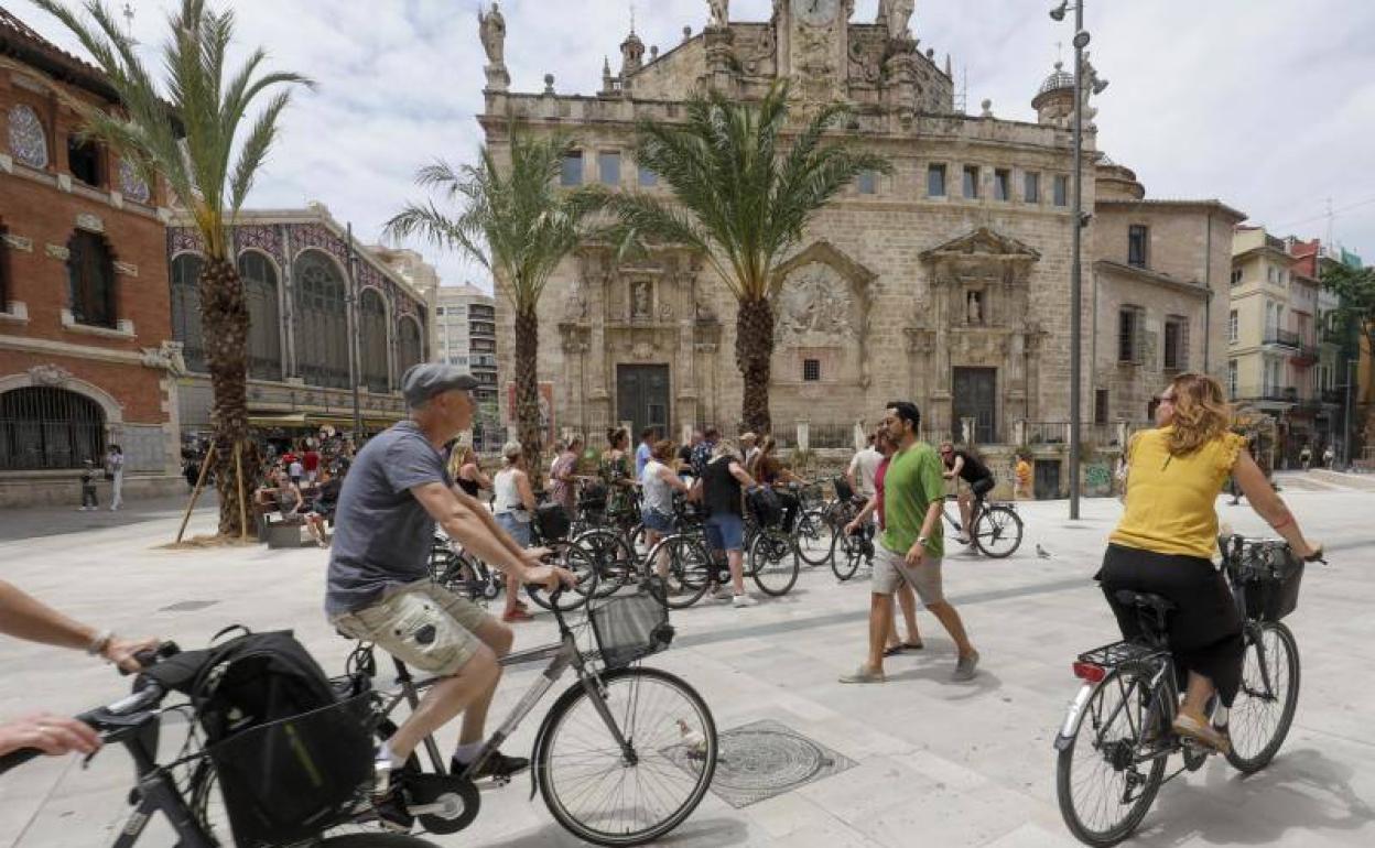 Turistas realizando visitas guiadas en bicicleta en la plaza del Mercado. 