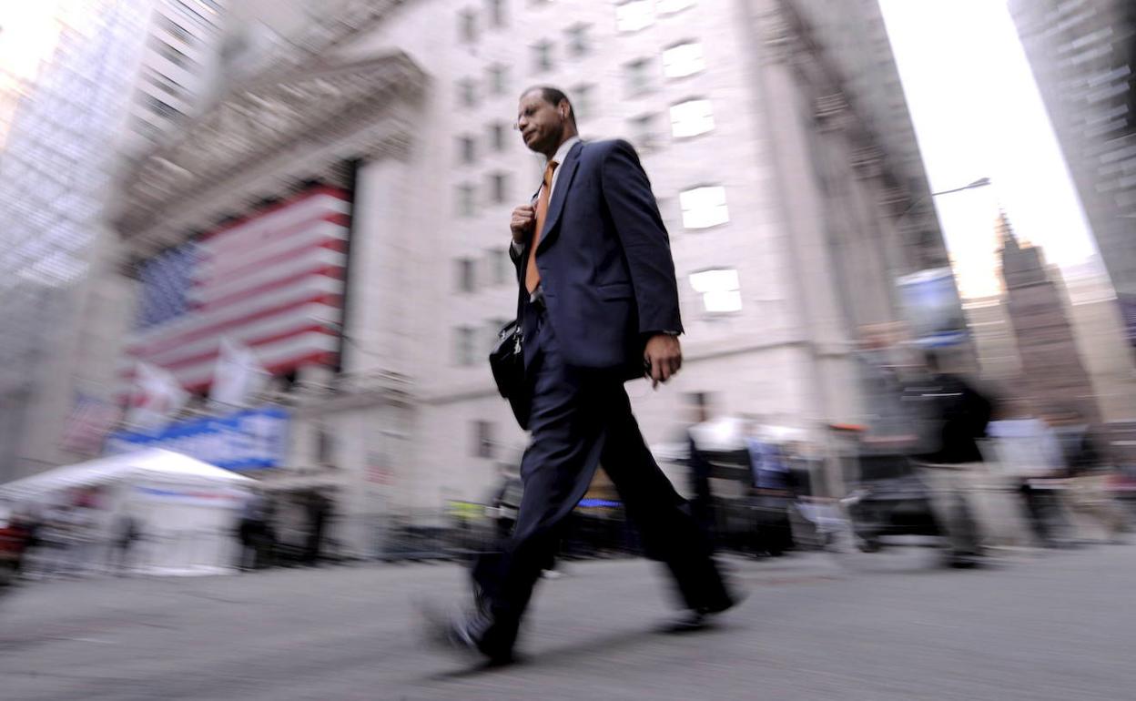 Un ciudadano camina frente a Wall Street. 