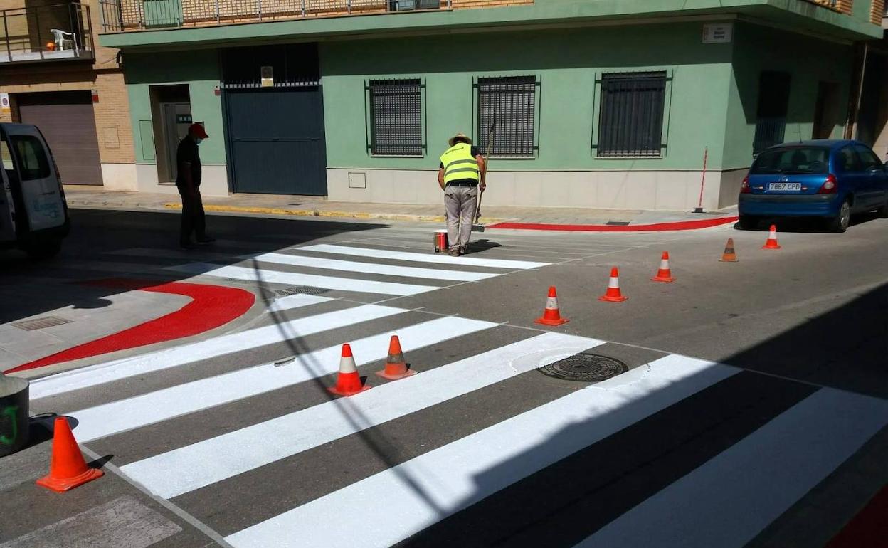 Un trabajador pinta dos pasos de peatones. 