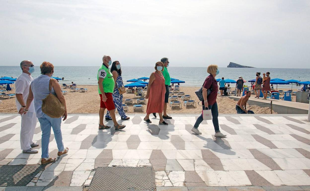 Un grupo de personas pasea por la playa de Levante de Benidorm. 