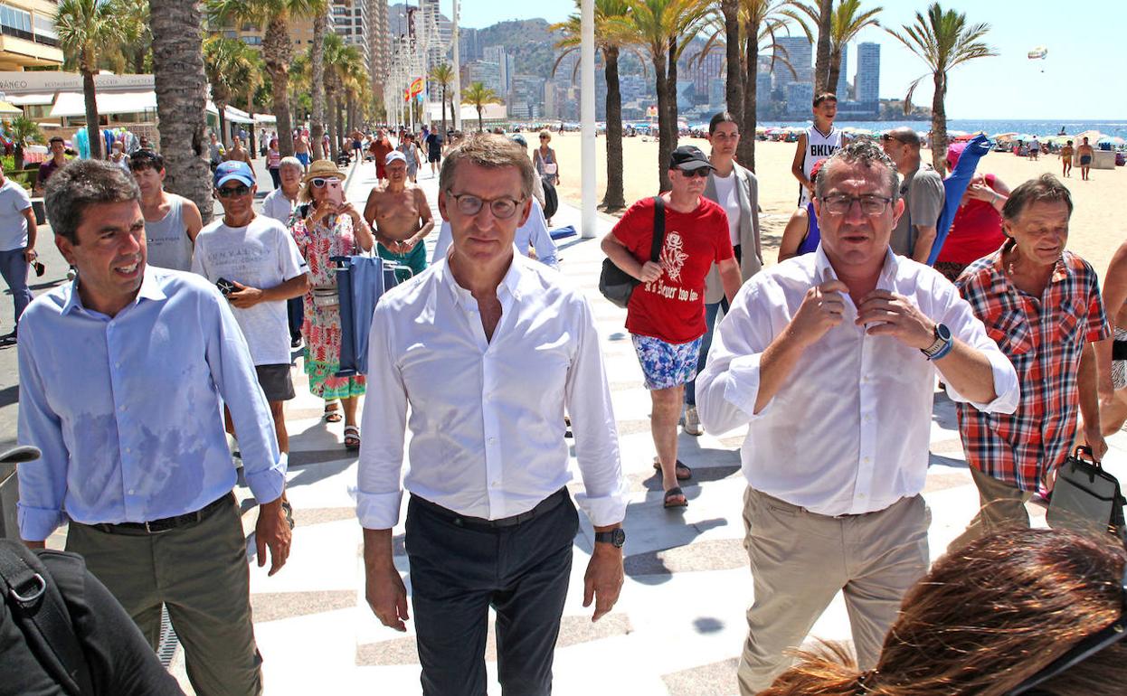 Feijóo, flanqueado por Carlos Mazón y Toni Pérez, pasea por la playa de Levante. 