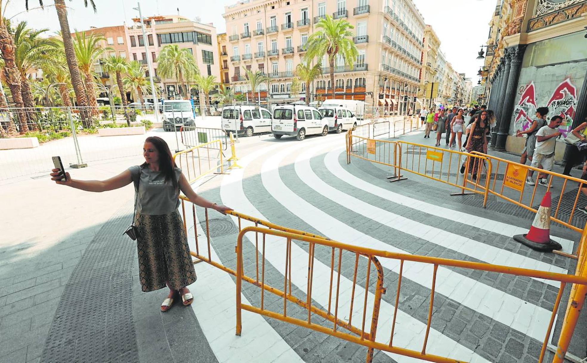 Una joven se hace una foto con el móvil junto al gigantesco paso de peatones de la plaza de la Reina. 