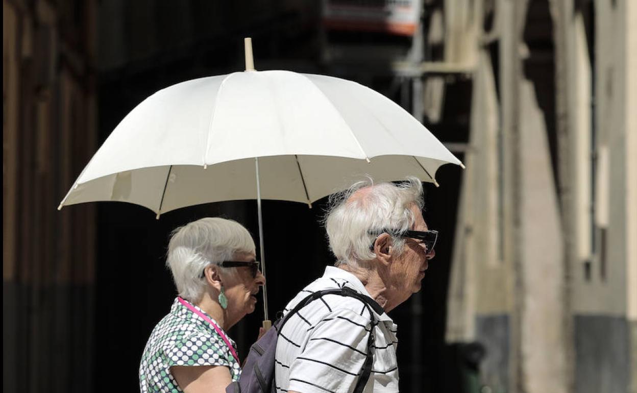 Dos personas se protegen del sol en Valencia. 